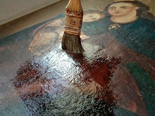 Imagen utilizada para el servicio de restauración de pinturas al óleo donde se observa como una persona realiza dicho trabajo con un pincel